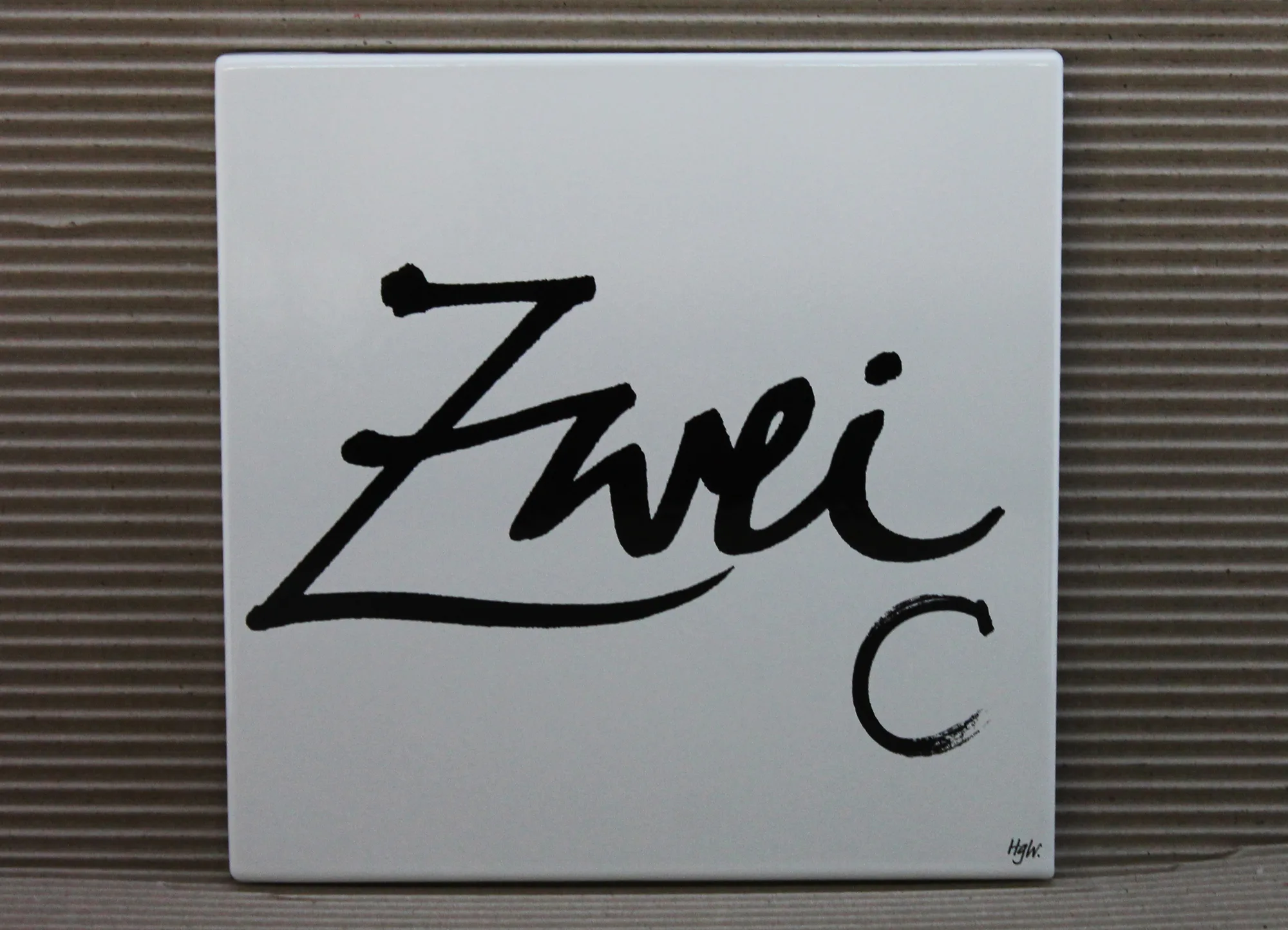 Design-Hausnummer „Zwei“ mit Zusatz C auf weißem Emailschild