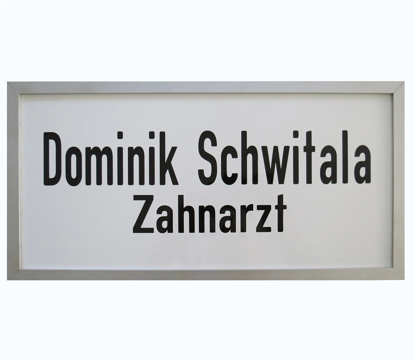 Praxisschild eines Zahnarztes aus weißem Email